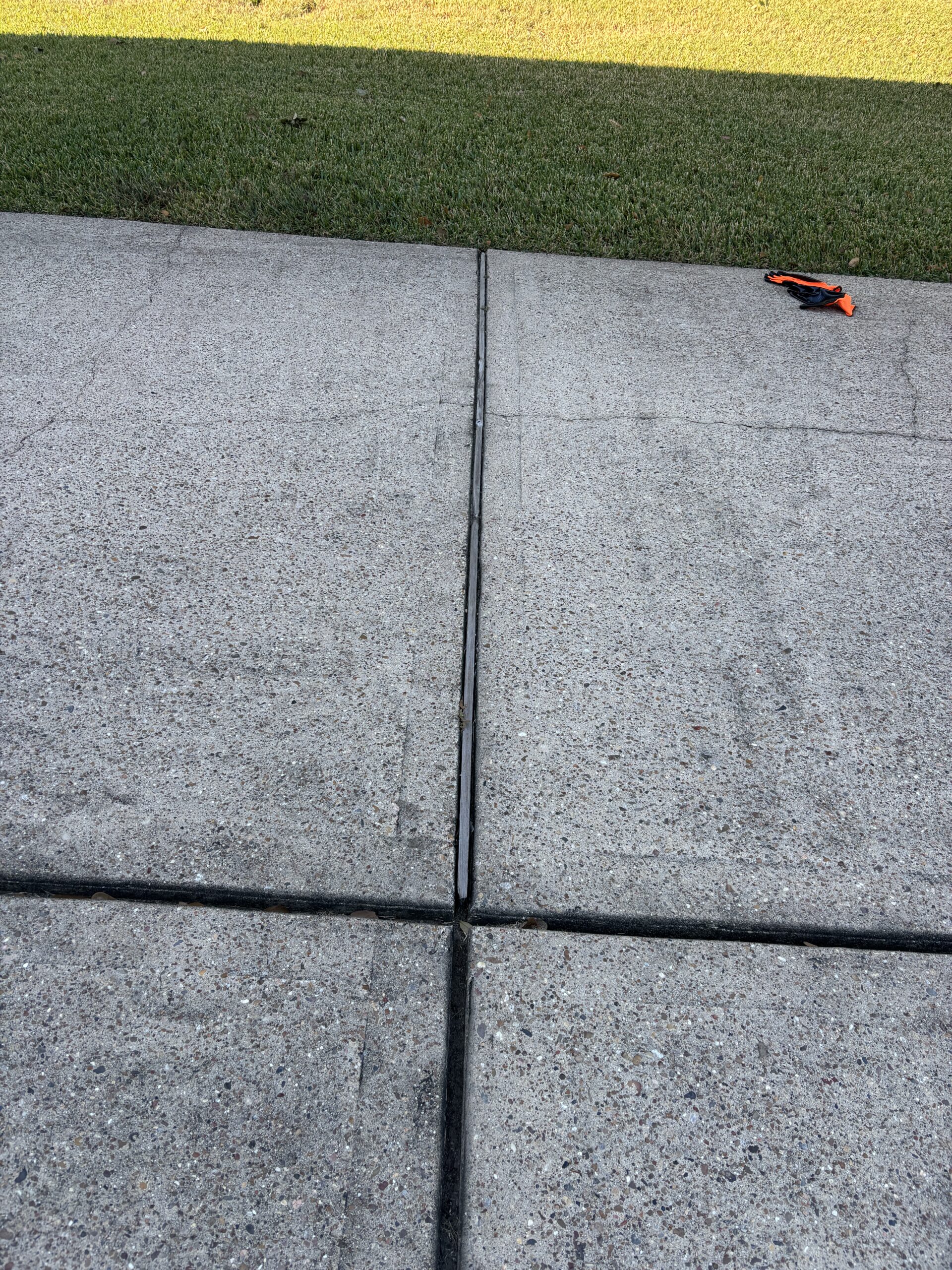 Driveway concrete expansion joints sealed to prevent water intrusion and slab settlement by Ro-Berg Concrete Repair Specialist.